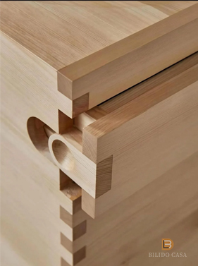 Detail of custom light wood furniture’s mortise and tenon joint, exemplifying traditional woodworking excellence.
